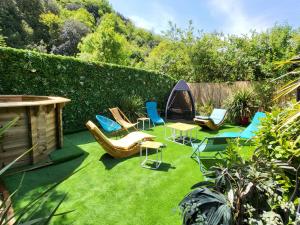 a garden with chairs and a tent on the grass at le petit chalet cevenol in La Barriére