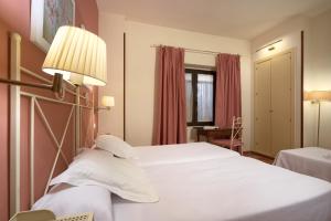 מיטה או מיטות בחדר ב-Hotel Murillo