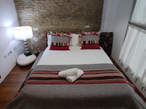 a bedroom with a large bed with pillows at Apartamento Un Jardin en la Alfalfa - Kainga Homes in Seville