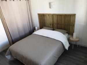 um quarto com uma cama branca e uma cabeceira em madeira em casa di a piaghja em Borgo