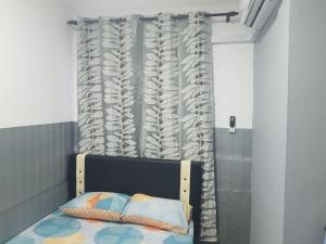 a bedroom with a bed and a curtain at Orchid Roomstay in Labuan