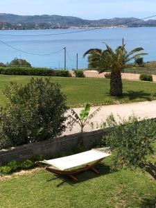 a bench sitting in the grass next to a beach at Aloni Studios and Apartments in Lassi