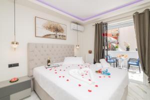una camera da letto con un grande letto bianco con fiori sopra di Alkeos Suite by "elite" a Città di Zante