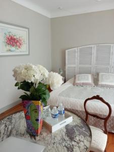 Un dormitorio con una cama y una mesa con un jarrón de flores en La Forge, en Rustrel
