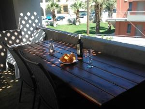 een tafel met een fles wijn en een schaal fruit bij Fotula Studios in Agia Pelagia