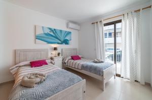 ein Schlafzimmer mit zwei Betten und einem großen Fenster in der Unterkunft Voltor BE in Port de Pollença + 20 Fotos