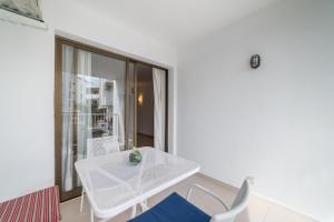 ein weißes Esszimmer mit einem weißen Tisch und Stühlen in der Unterkunft Voltor BE in Port de Pollença