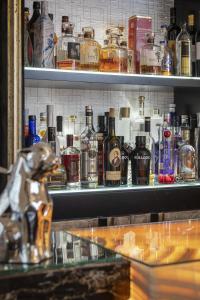 a shelf filled with lots of bottles of alcohol at 6000sqft Apartment on Park Lane with Private Swimming pool,Gym&Sauna in London