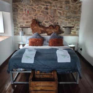 Un dormitorio con una cama grande con una pared de piedra. en La casa de la Tina, en Porquera de Santullán