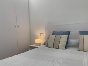 a bedroom with a bed with blue and white pillows at Apartamento Botánico, Centro de Granada in Granada