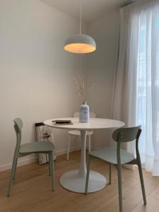 a white table with two chairs and a vase on it at Apartamento Botánico, Centro de Granada in Granada
