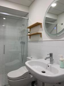 a bathroom with a sink and a toilet and a mirror at Apartamento Botánico, Centro de Granada in Granada