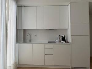 a kitchen with white cabinets and a sink at Apartamento Botánico, Centro de Granada in Granada