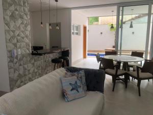 a living room with a couch and a table at Casa Piscina AQUECIDA PRIVATIVA Serv Praia Condom Fechado! in São Sebastião