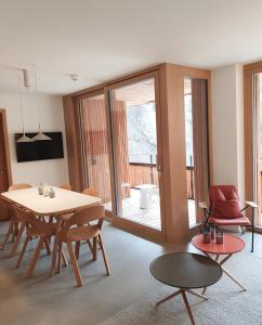 a dining room with a table and a table and chairs at Ferienwohnung Stenna SELVA an Toplage in Flims