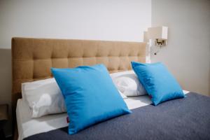 ein Bett mit blauen und weißen Kissen darauf in der Unterkunft AQUARIUS APARTMENTS by DuHomes in Dubrovnik