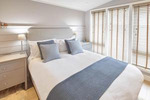 a bedroom with a large white bed with two blue pillows at Host & Stay - Puffins Rest in Runswick