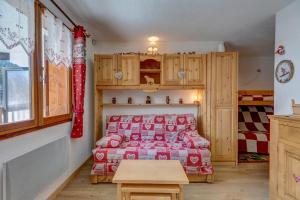 una camera con un letto con una coperta rossa di La Loutre a La Giettaz