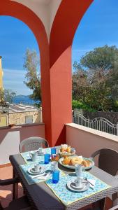 un tavolo con piatti di cibo su un balcone di La Casa del Sole sul mare di Ischia a Ischia