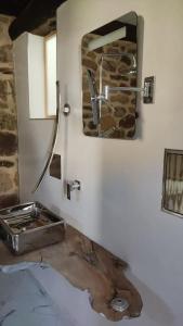 baño con lavabo y espejo en la pared en La casa de la Tina, en Porquera de Santullán