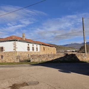 Un antiguo edificio de piedra al costado de una calle. en La casa de la Tina, en Porquera de Santullán