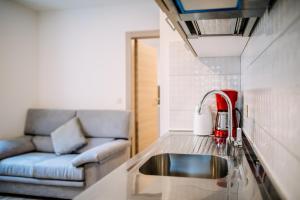 eine Küche mit einem Waschbecken und einem Sofa in der Unterkunft AQUARIUS APARTMENTS by DuHomes in Dubrovnik