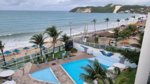 a view of the beach from the balcony of a resort at Hotel Ponta Negra Beach by Oxequealuguel in Natal