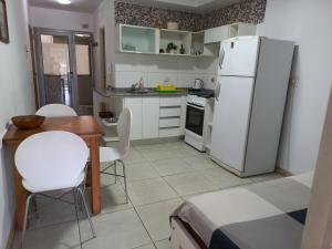 a kitchen with a white refrigerator and a table and chairs at Mendoza 2138 Apartamento in Rosario