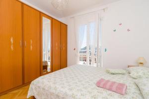 ein Schlafzimmer mit einem Bett mit einem rosa Kissen darauf in der Unterkunft Ivo Guest House in Dubrovnik