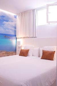 a hotel room with a white bed and white walls at Apartamentos Llobet Ibiza in Ibiza Town