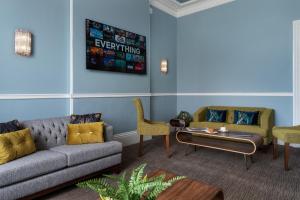 ein Wohnzimmer mit einem Sofa, Stühlen und einem Tisch in der Unterkunft St Andrews Hotel in Exeter