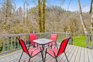 a table and four chairs on a wooden deck at RiverSong in Tillamook