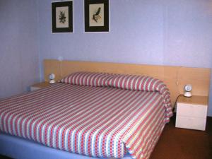 ein Bett in einem Schlafzimmer mit zwei Bildern an der Wand in der Unterkunft Hotel Residence Universo in Pré-Saint-Didier