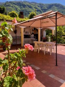 un patio con una mesa y una sombrilla en Villa Ciro, en Castellammare di Stabia