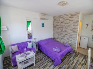 una camera con letto viola e divano di Apartments Good Vibrations a Rožat