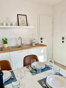 a kitchen with a table with plates and wine glasses at Resto domki letniskowe in Sarbinowo