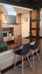 eine Küche mit einem Tisch mit 2 Stühlen und einer Uhr in der Unterkunft Loft Mariola - Apartamento en el centro histórico in Bocairent