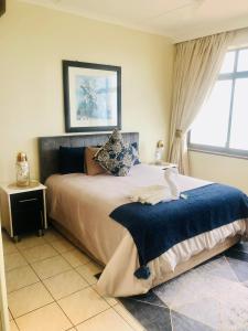 a bedroom with a large bed and a window at Penthouse 42 at Ezulweni in Amanzimtoti