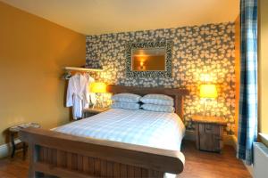 1 dormitorio con cama y espejo en la pared en Little John Hotel, en Hathersage