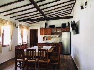a kitchen with a table and chairs and a refrigerator at Вила Вълнара in Sredets