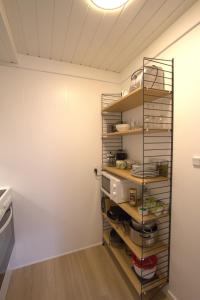 a kitchen with a shelf with dishes on it at Cosy apartment near beach, marina & city centre in Tórshavn