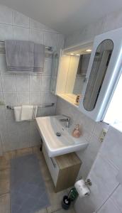 a white bathroom with a sink and a mirror at Sepps Appartement in Fieberbrunn