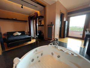 a large bath tub in a room with a bed at Attico con vista spettacolare e Jacuzzi in Bologna +22 photos