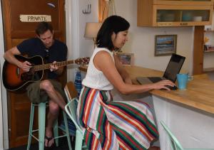 a woman sitting at a counter with a man playing a guitar at SURF HOSTEL BIARRITZ in Biarritz