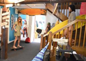 a woman riding a skateboard in a room with bunk beds at SURF HOSTEL BIARRITZ in Biarritz