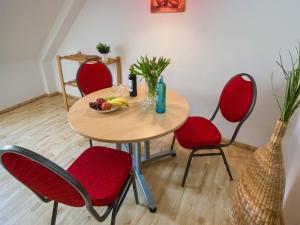 a table with red chairs and a bowl of fruit on it at Wohnen am Schloss, Schlossblick in Sondershausen +2 photos