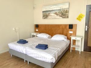 een slaapkamer met een bed met twee handdoeken erop bij Bed & Ontbijt Haddock in Almere