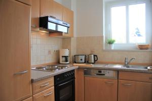 a kitchen with a sink and a stove top oven at Wittes Wohnung in Am Schwarzen Busch
