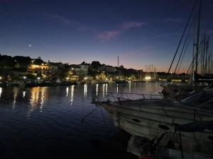 a boat is docked in a harbor at night at LUPA - La flotta di Willy Giò in Alghero