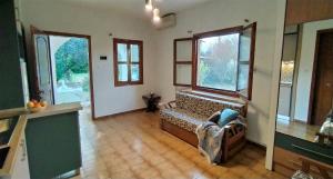 ein Wohnzimmer mit einer Bank in einem Zimmer mit Fenstern in der Unterkunft Garden Bungalow Valentina in Stavros